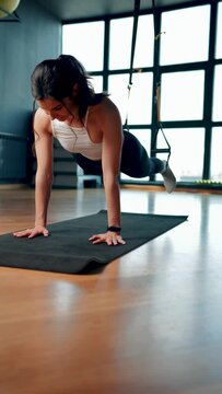 Beautiful woman doing exercise with trx system.Fitness exercises with loops.Concept workout healthy lifestyle sport.Vertical video