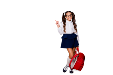 Full size body length of glad girlish nice smart cute small little girl with curly ponytails in white blouse shirt and blue skirt with red bag, pointing finger up, offer. Isolated on black background