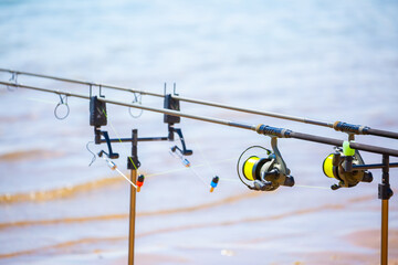 Close-up of fishing rod reels. Fishing on the shore of the lake. Spinning rods for sport fishing.