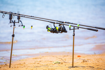 Close-up of fishing rod reels. Fishing on the shore of the lake. Spinning rods for sport fishing.