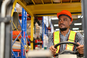warehouse worker driving a forklift at shipping warehouse. Industrial engineer man in safety vest...