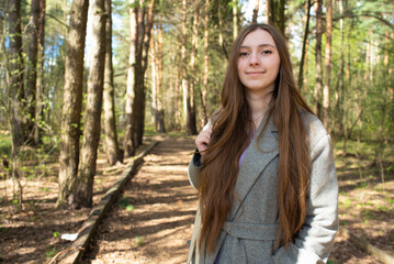 Portrait of a beautiful young girl with long hair in the forest