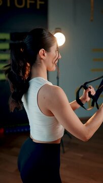 Beautiful woman doing exercise with trx system.Fitness exercises with loops.Concept workout healthy lifestyle sport.Vertical video