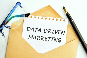 DATA DRIVEN MARKETING text an inscription on a piece of paper peeking out of an envelope next to...