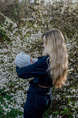 young beautiful mother with her newborn baby outdoors enjoying the spring 