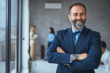 Cropped shot of a businessman standing in the office with his arms folded looking confident and...