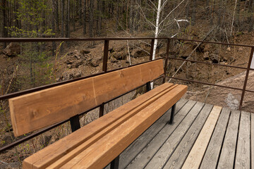 Public recreation area for rest in the forest or nature park. Bench from terrace deck boards....