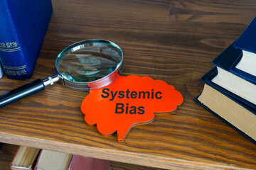 Systematic bias concept. Sign and magnifying glass on the shelf.