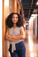 Portrait Of Smiling Businesswoman Standing In Corridor Of Modern Office Building