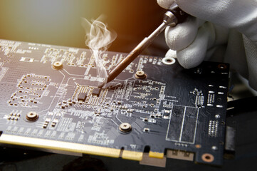 Technician who is repairing circuits, technician repairing and soldering circuits Graphics card...