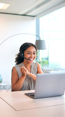 Woman Wearing Headset Sitting At Desk With Laptop Celebrating Good News Or Hitting Sales Target