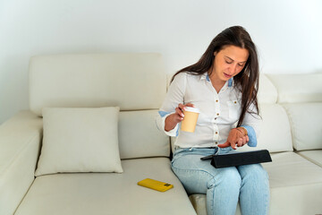 Middle-aged Romanian businesswoman teleworking from her home sofa