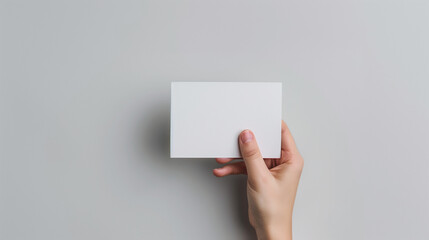 Obraz premium Hand Holding Blank Card on Light Background