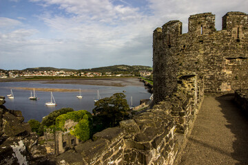 Fototapeta premium View over the Conwy Estuary with the ruins of the castle walls in the foreground, Conwy, North Wales
