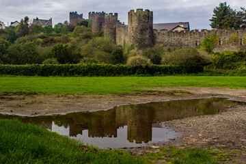 Reflections of the Medieval Walls of the town of Conwy, North Wales, in a small puddle