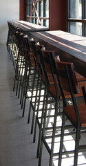 Tall chairs at a bar along the window