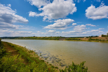 Beautiful landscape. Wide river, blue sky with white clouds.