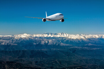 A white wide body aircraft fly over resort mountain town