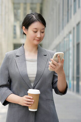Businesswoman Multitasking with Coffee and Smartphone