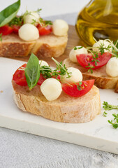 Round mozzarella, cherry tomatoes and microgreens on a piece of white bread