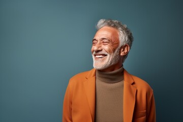 Portrait of a cheerful man in his 60s laughing in front of minimalist or empty room background