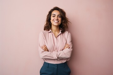 Fototapeta premium Portrait of a cheerful woman in her 20s with arms crossed isolated in minimalist or empty room background