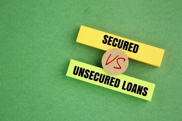two colored papers with the words Secured vs Unsecured Loans. Business concept