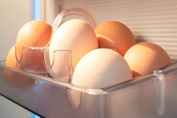 Organic eggs are stored in a transparent container inside a fridge, used as a key ingredient in...