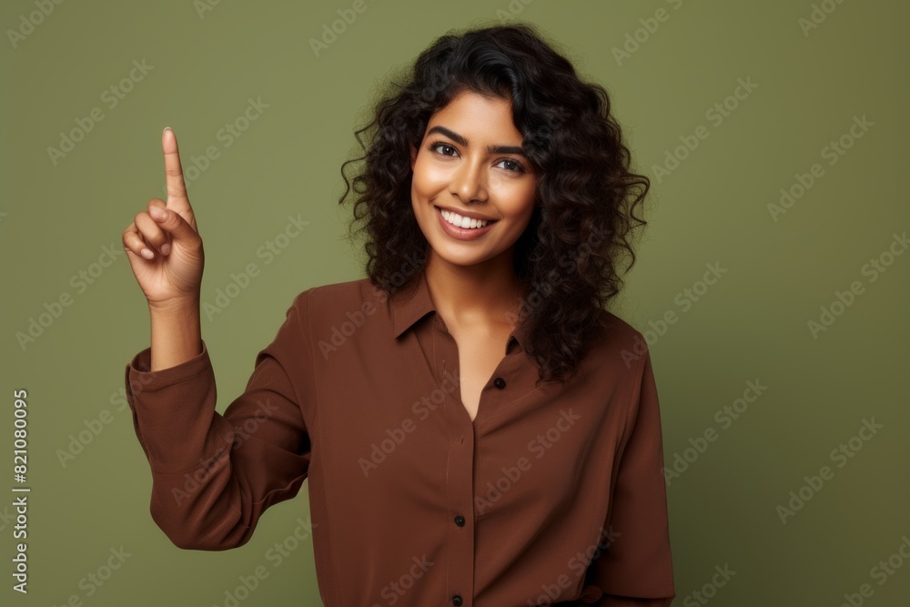 Wall mural Portrait of a content indian woman in her 30s showing a thumb up over solid color backdrop - Wall murals