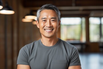 Obraz premium Portrait of a tender asian man in his 40s smiling at the camera on solid color backdrop