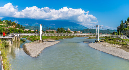A view down the River Osum towards a pedestrian suspension bridge in the Old Quarter in Berat,...