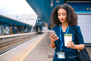 Female Doctor Or Nurse Commuting On Train Platform With Mobile Phone And Reusable Coffee Cup