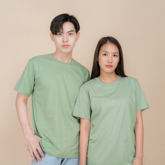 Fototapeta premium Young couple in casual green t-shirts posing together