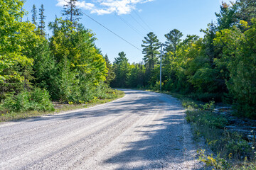 Gravel off road to Blue Jay Creek with Michael's Bay, Lake Huron, Manitoulin Island, unveils a nature-lover's paradise. Tranquil journey harmonious retreat and adventure in green forest.