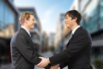 businessman shaking hands to partner outdoors