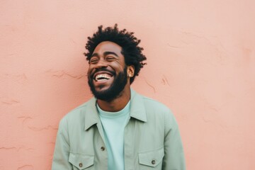 Portrait of a satisfied afro-american man in his 30s laughing isolated on solid pastel color wall