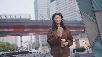 Modern Urban Woman Texting on Smartphone with Coffee