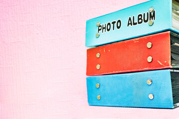 Old blue and red photo albums on a pink background