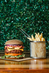 Hamburguer artesanal delicioso com fritas em fundo verde