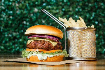 Hamburguer artesanal delicioso com fritas em fundo verde