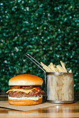 Hamburguer artesanal delicioso com fritas em fundo verde