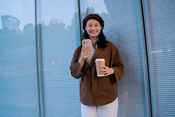 Stylish Woman Enjoying Coffee and Smartphone in City
