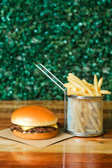 Hamburguer artesanal delicioso com fritas em fundo verde