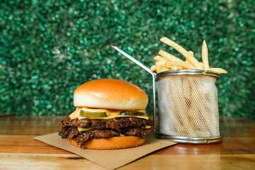 Hamburguer artesanal delicioso com fritas em fundo verde