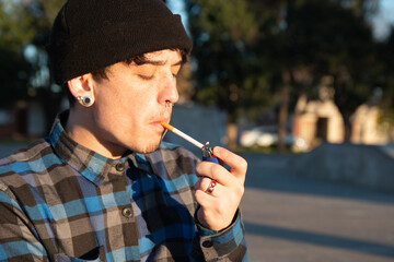 Chico joven encendiendo un cigarrillo