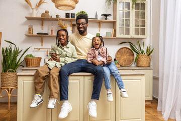 Cheerful dad with happy little children daughters having fun at home