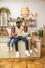 Cheerful dad with happy little children daughters having fun at home