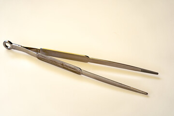 Close-up of isolated metal cooking tweezers on photo table outdoor at home terrace at Swiss City of Z&uuml;rich on a sunny spring afternoon. Photo taken May 20th, 2024, Zurich, Switzerland.