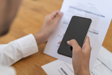 Bill pay concept. Online internet banking asian young man hand holding invoice use mobile smart phone spend scan barcode to transfer to pay money of credit card without cash. Technology of financial.