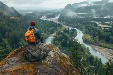 A man sits on a rock overlooking a river - Powered by Adobe